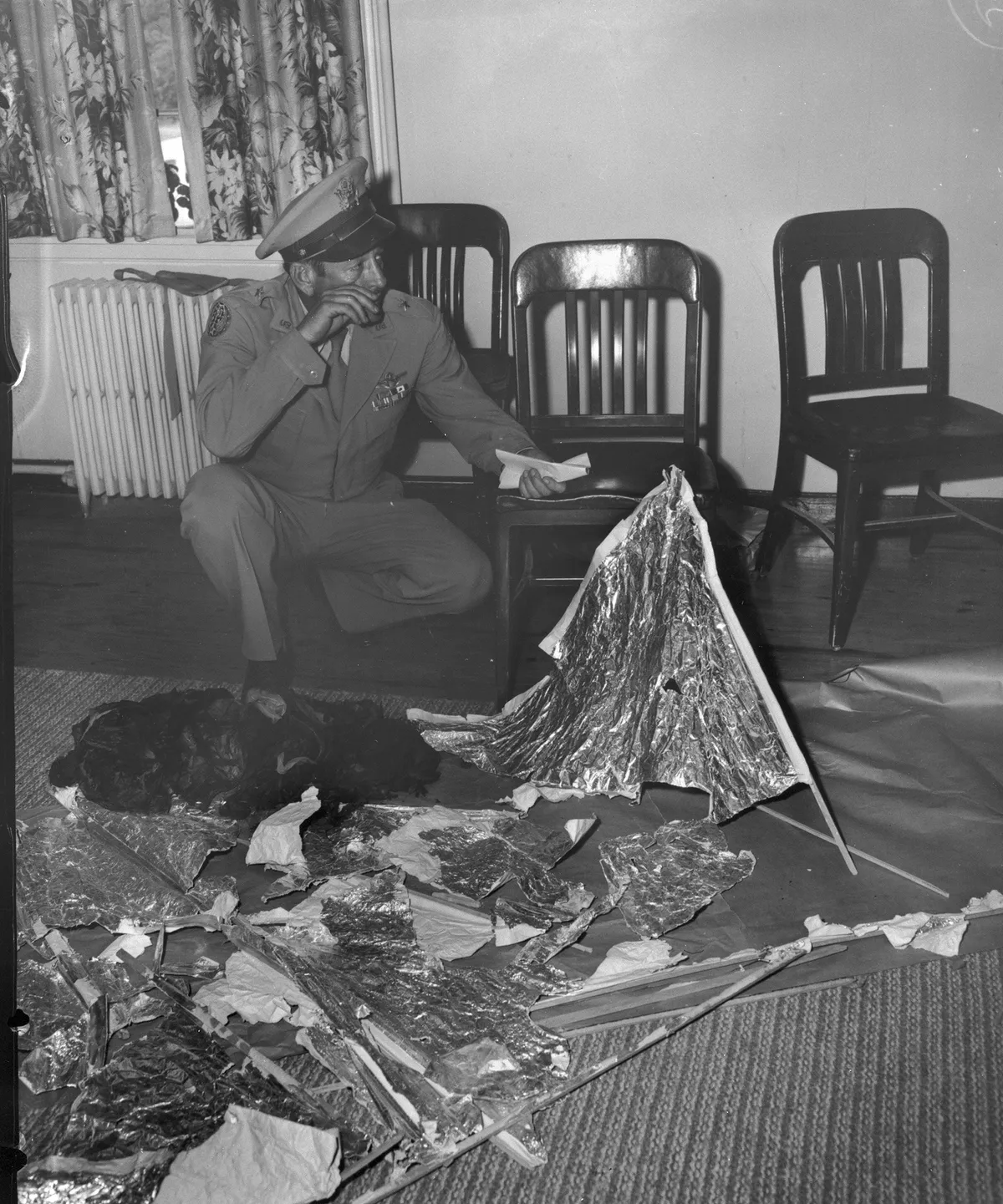 Brig. Gen. Ramey holding telegram with debris